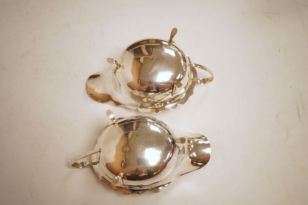 A pair of 1930's silver sauceboats, with cut borders, Barker Brothers Silver Ltd, Birmingham, 1935 and 1938, length 14.6cm, 5.8oz.